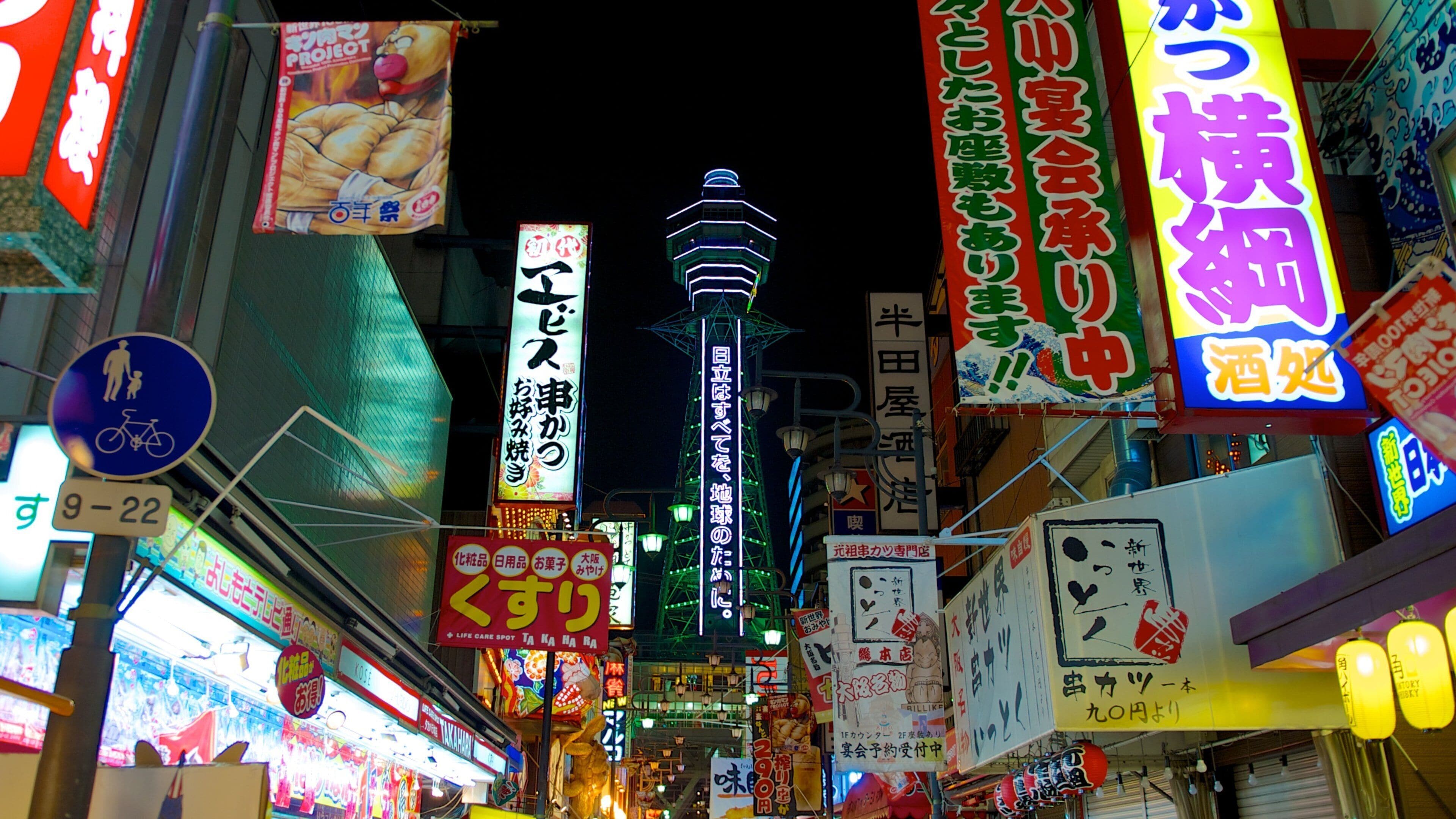 Tsutenkaku Tower featuring signage, a city and street scenes