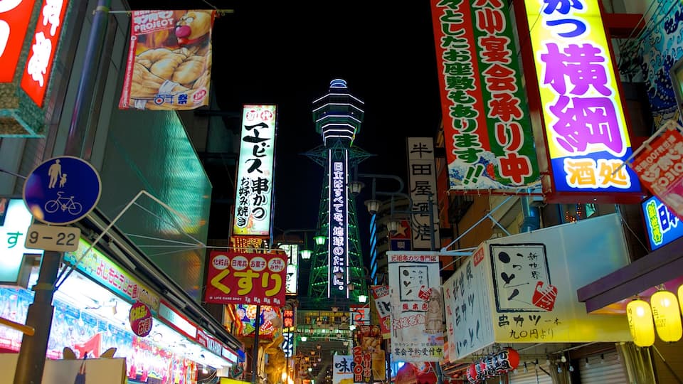 Tsutenkaku Tower featuring signage, a city and street scenes