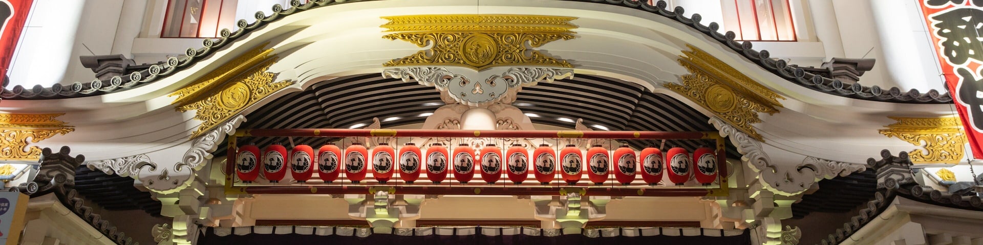Un edificio tradicional con arquitectura ornamentada, que incluye un techo curvo y faroles rojos.