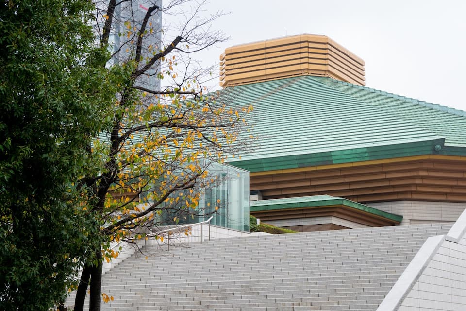 A building with a green roof and a brick staircase leading up to it.