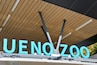 The entrance to Ueno Zoo with large turquoise letters and a wooden ceiling.