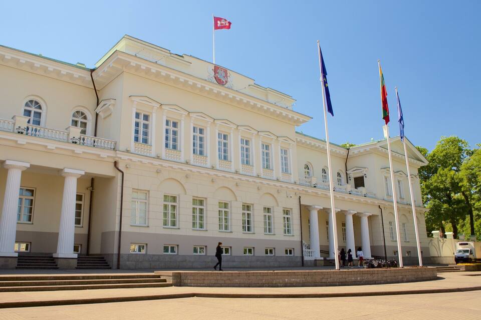 Ein großes, klassizistisches Gebäude mit Säulen und Flaggen.