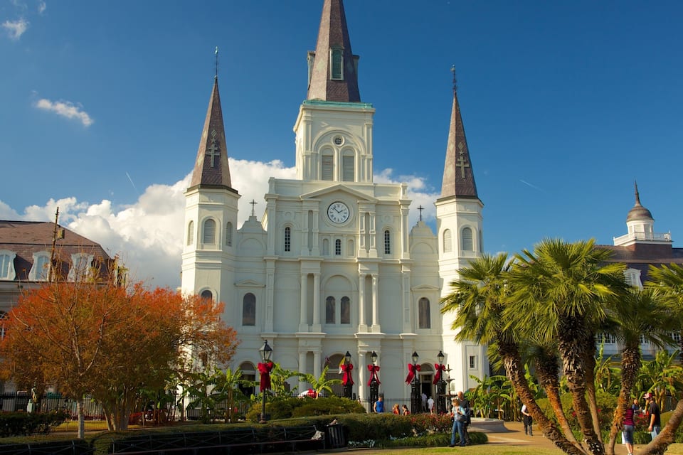 A large white church with three spires and a clock tower.
