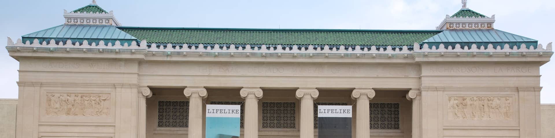 A neoclassical building with columns and banners.
