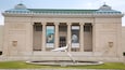 A neoclassical building with columns and banners.