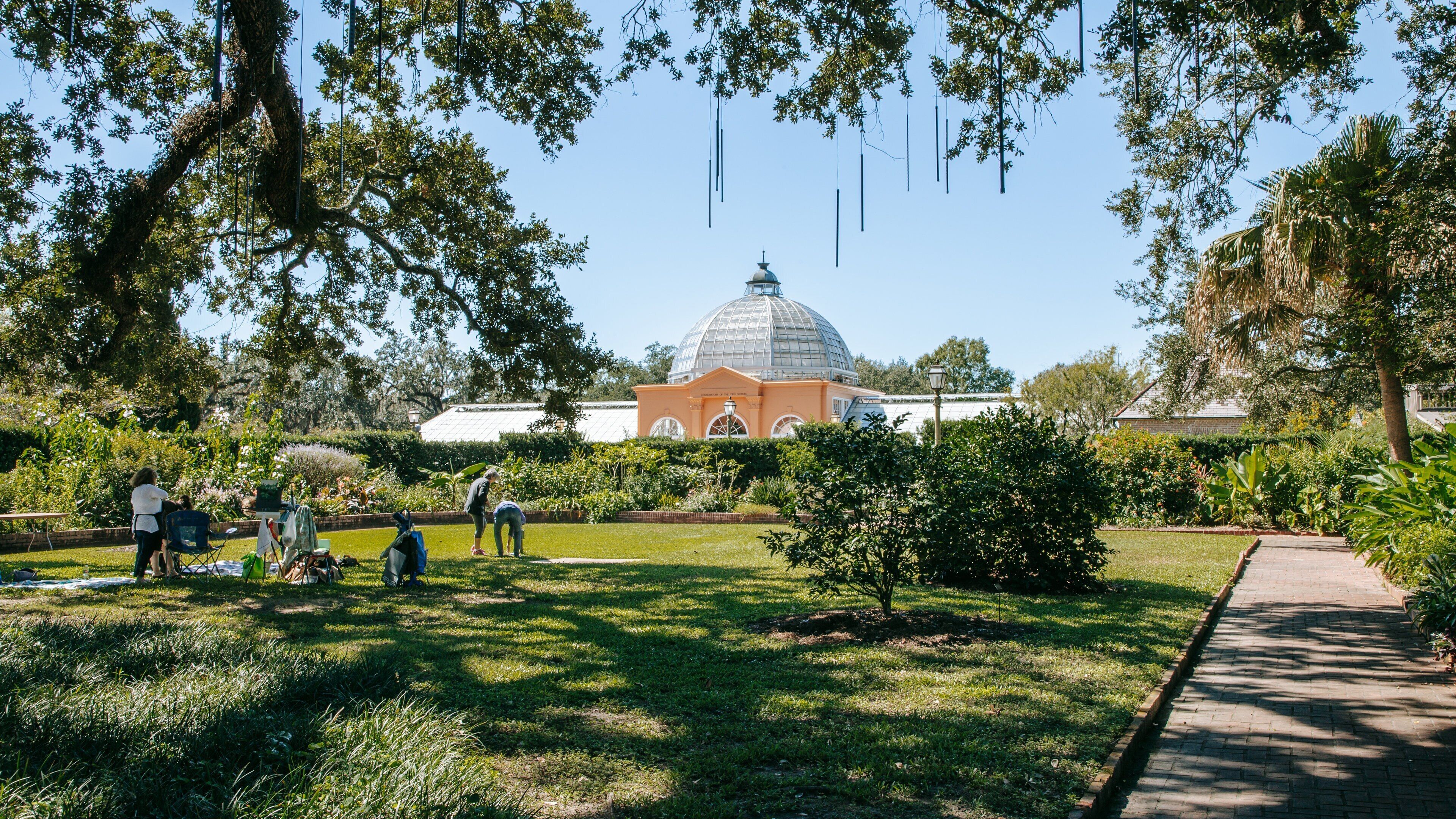 New Orleans Botanical Garden showing picnicing and a garden as well as a small group of people