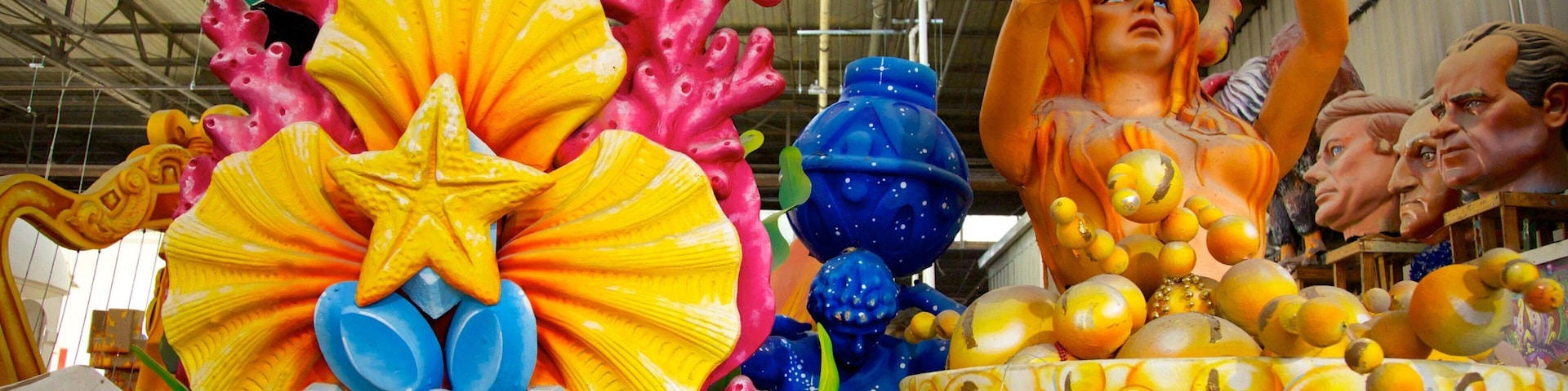 Uma escultura colorida com uma estrela, flores e uma figura segurando uma bola.