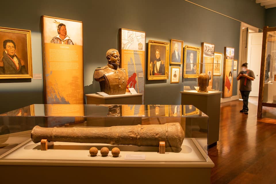 A museum exhibit with historical artifacts and portraits.