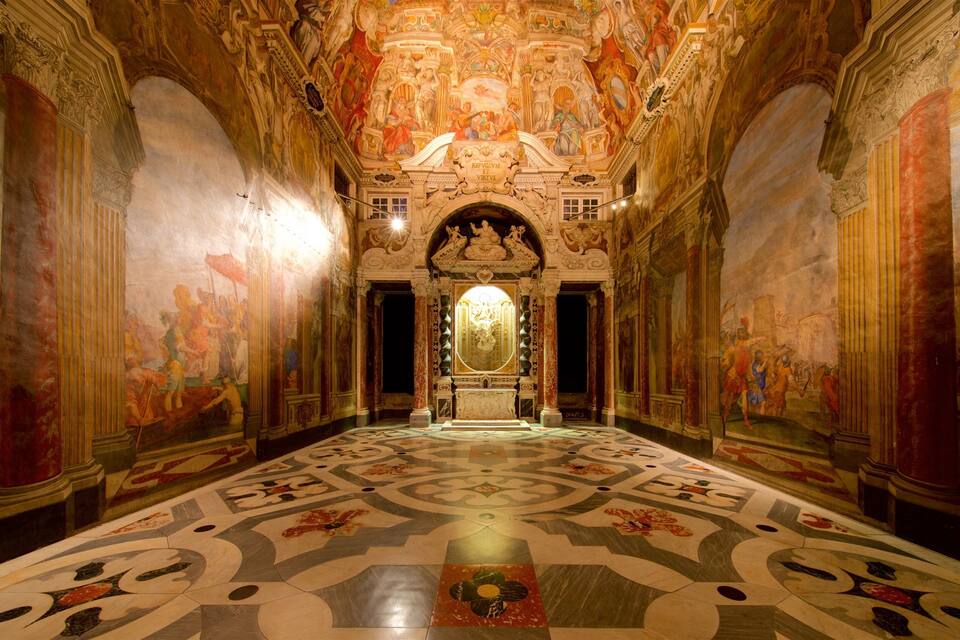 An ornate hall with a central altar, elaborate frescoes, and a patterned floor.