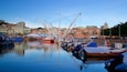 A harbor with boats, a bridge, and historic buildings.