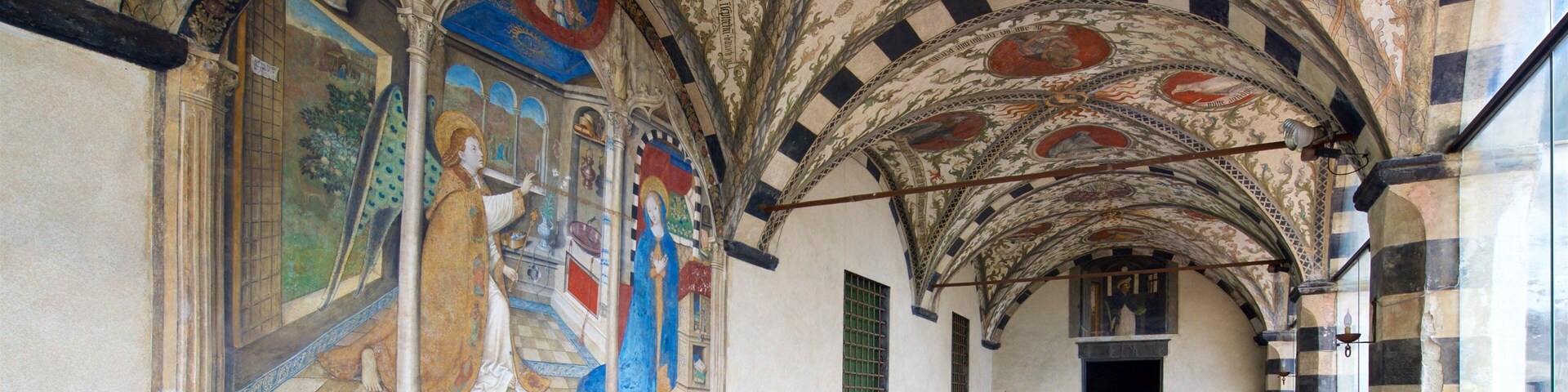 A historic building with intricate frescoes and a checkered floor.