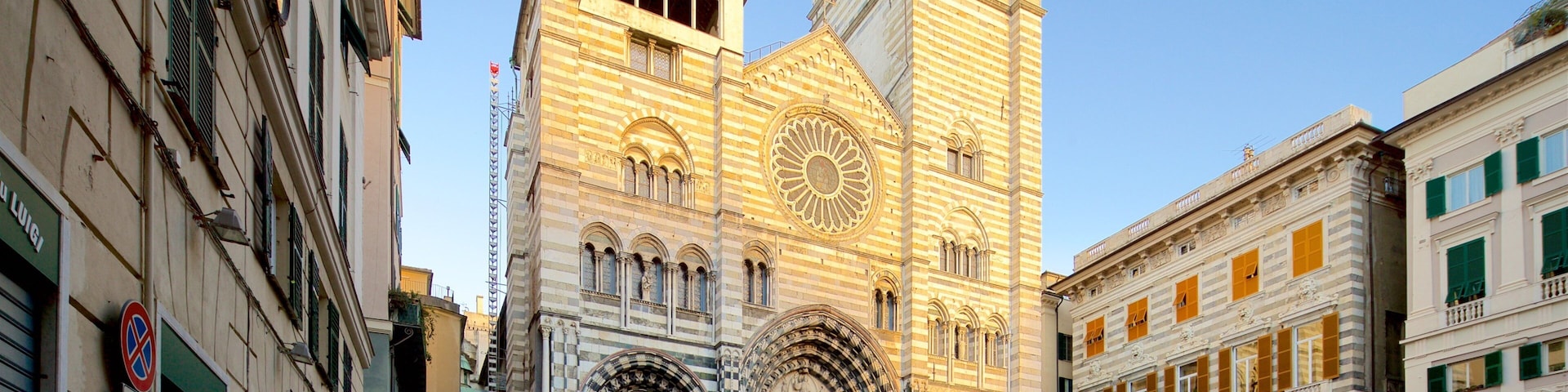 Uma catedral histórica com arquitetura detalhada, um relógio imponente e uma praça movimentada.