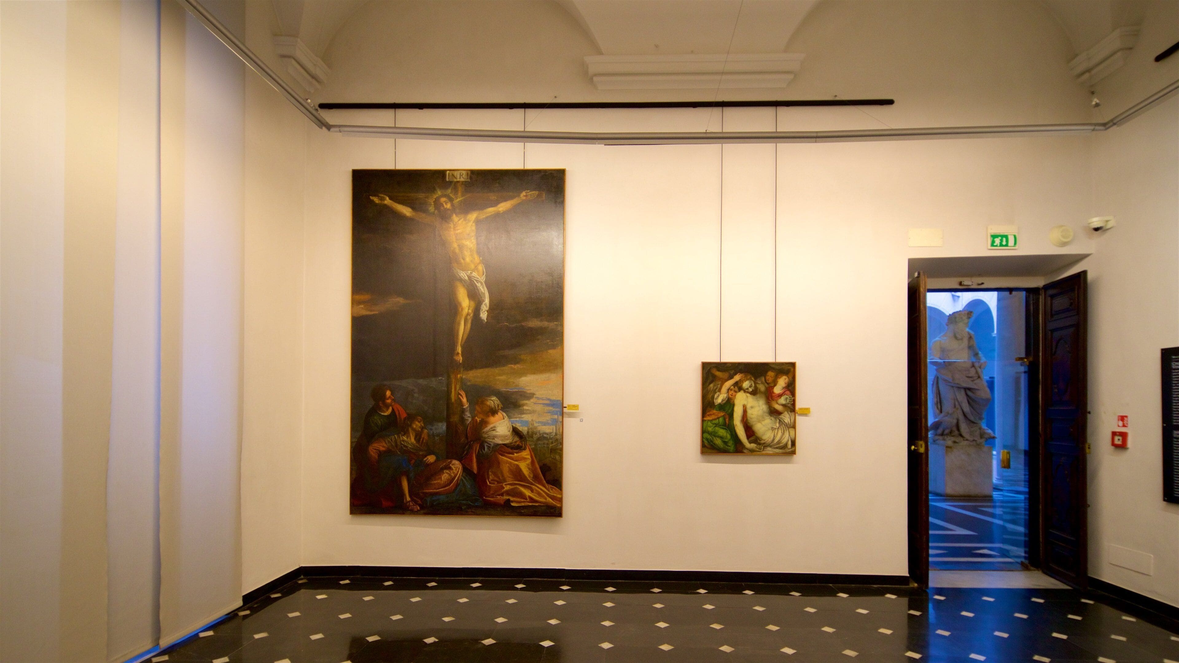 En hall med en stor målning som föreställer en korsfästelse, en mindre målning och en staty.