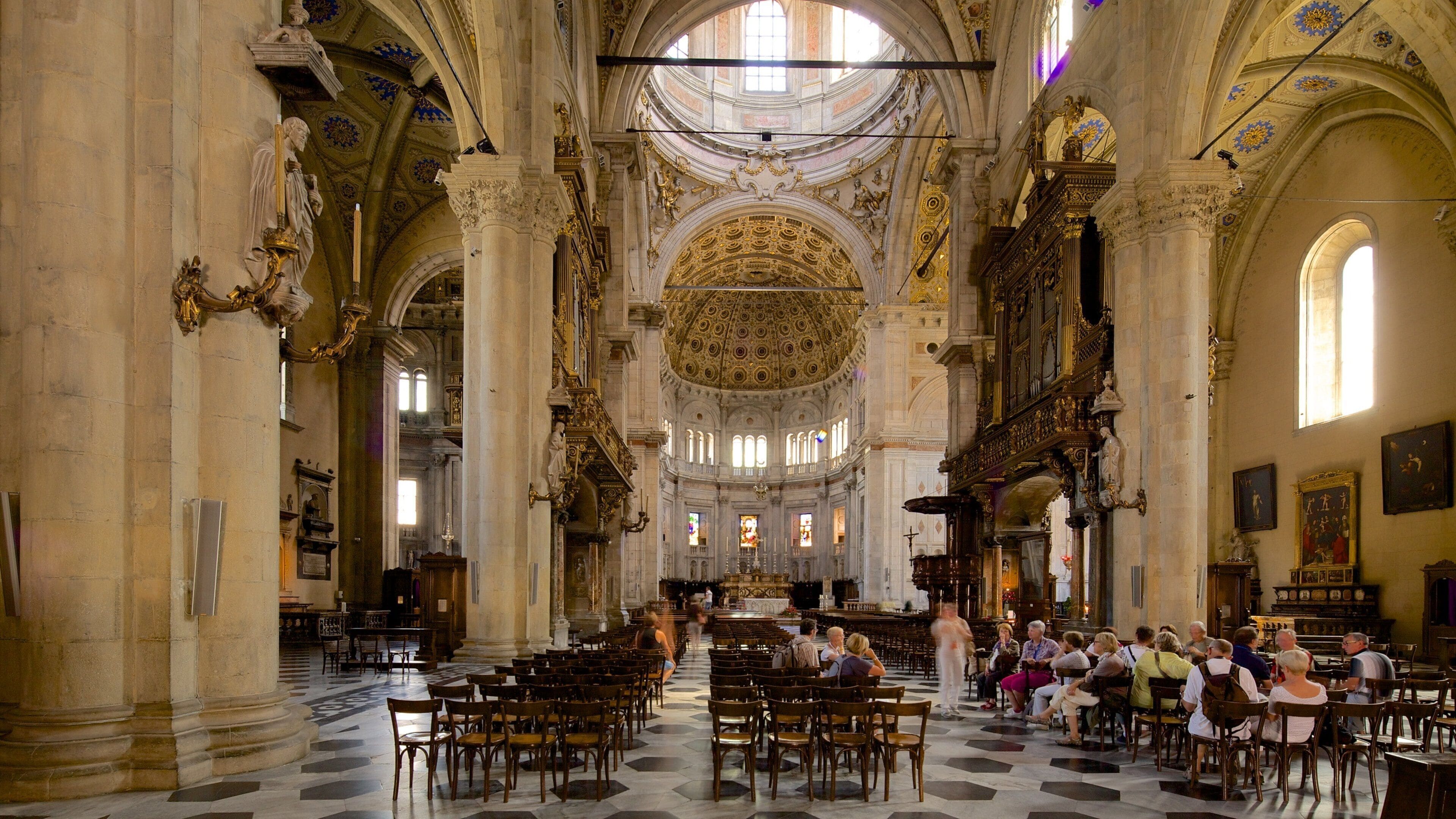 Lago di Como som viser innendørs og kirke eller katedral i tillegg til en stor gruppe med mennesker