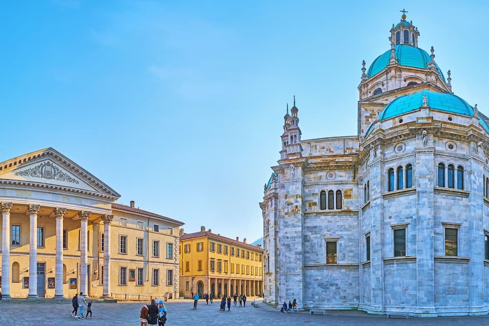A historic square with classical architecture, including a prominent building with a blue dome and another with columns.