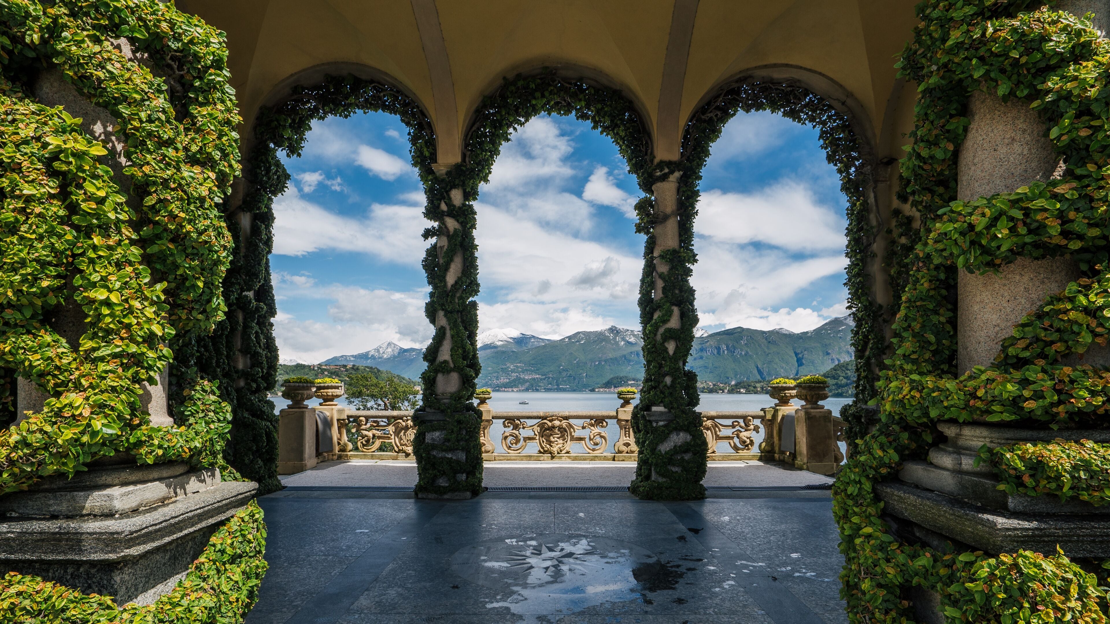 Lenno and Lake Como view with ivy Loggia columns from the balcony of Villa del Balbianello, Italy