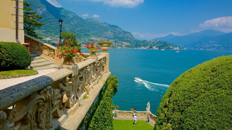 A scenic view of a lake with boats, a mountain in the background, and ornate architecture along the waterfront.