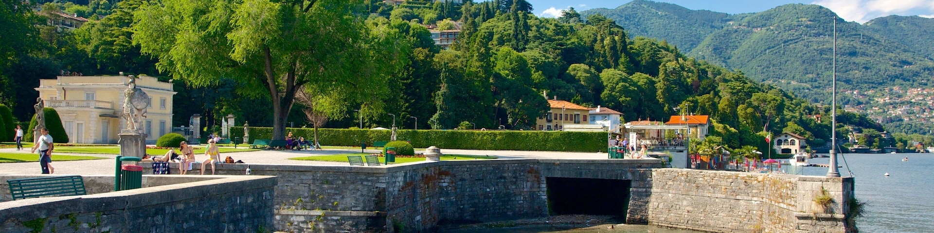 Un muelle histórico con escalones de piedra que descienden a un río tranquilo, rodeado de vegetación exuberante y con colinas al fondo.