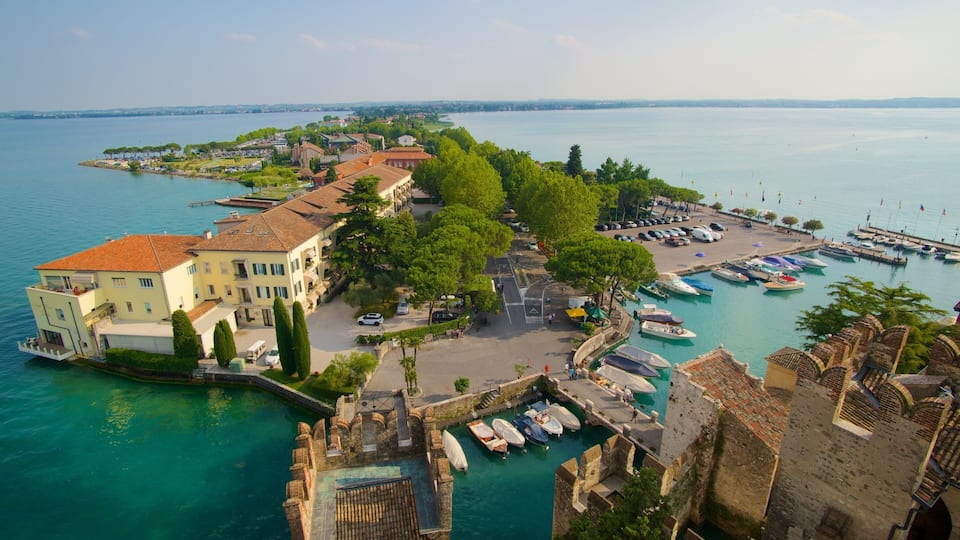 Una cittadina costiera con un porto turistico, edifici storici e una vista limpida sul mare.