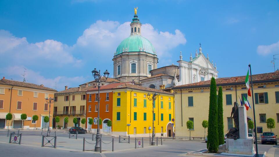 A street with colorful buildings, a prominent yellow building, and a large dome structure in the background.