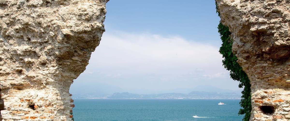 Grotto of Catullus showing a ruin, heritage elements and a lake or waterhole
