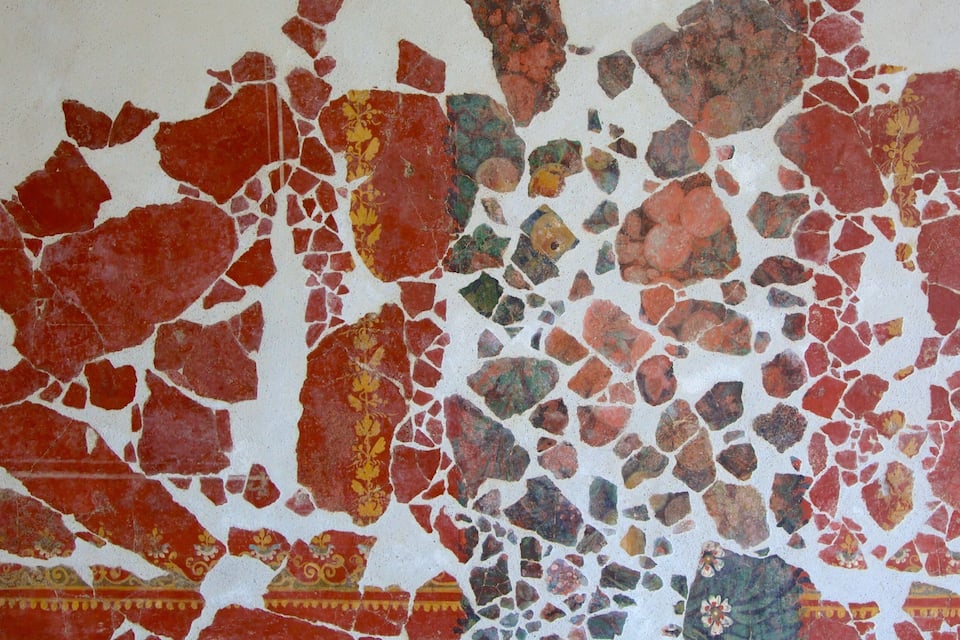 A mosaic with red, green, and yellow pieces.