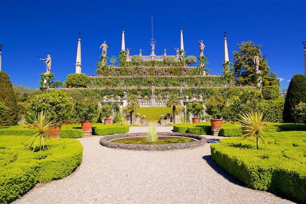 Un jardin à la française, agrémenté de statues, d’une fontaine et de haies taillées avec soin.