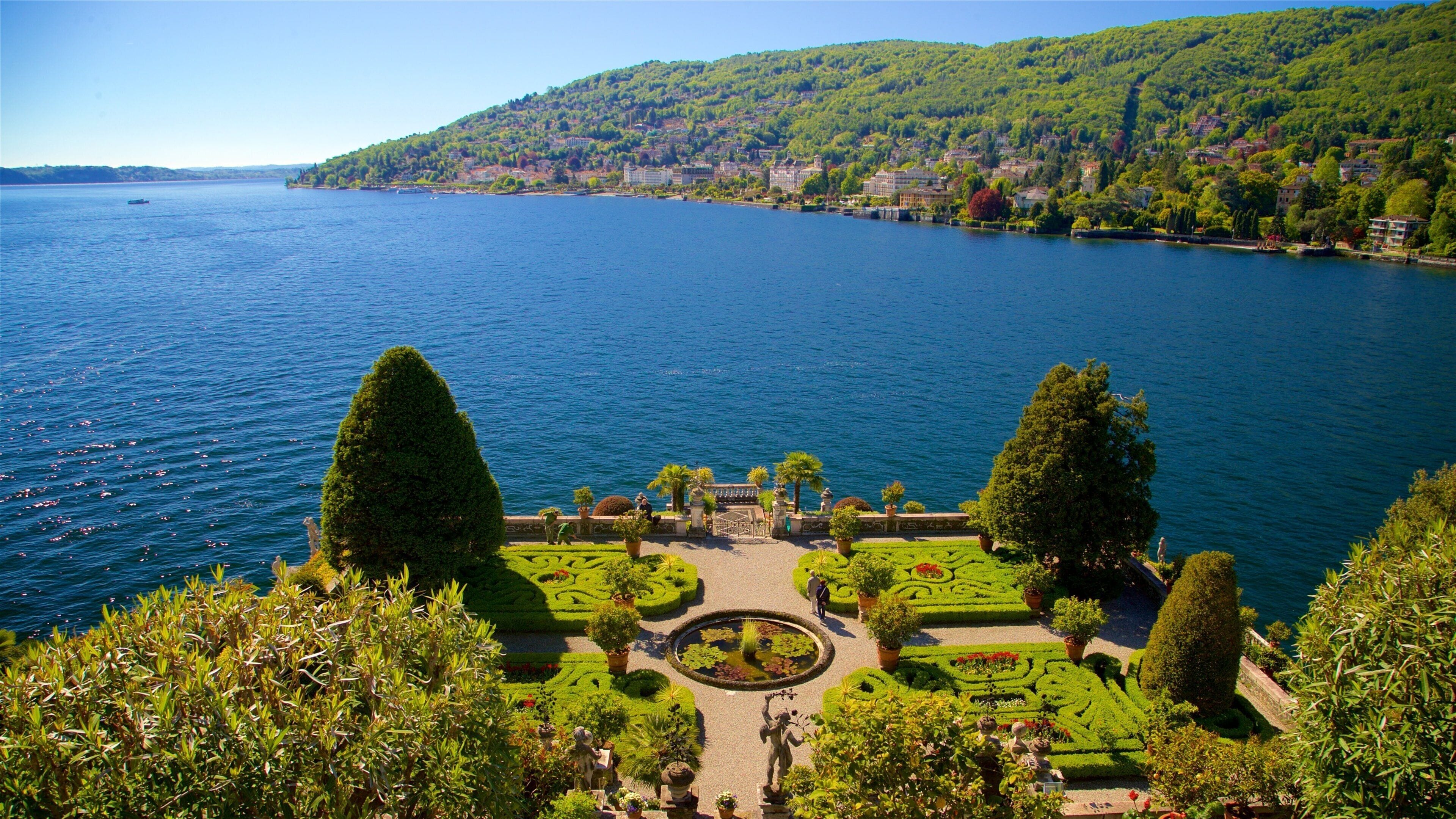 Isola Bella Botanical Garden featuring a lake or waterhole and a garden