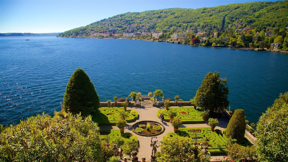 A lake with a well-manicured garden, a circular pond, and a distant cityscape.