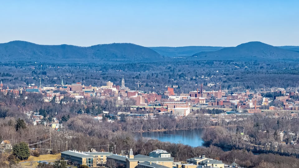 A cityscape with a river, mountains, and a mix of urban and natural landscapes.