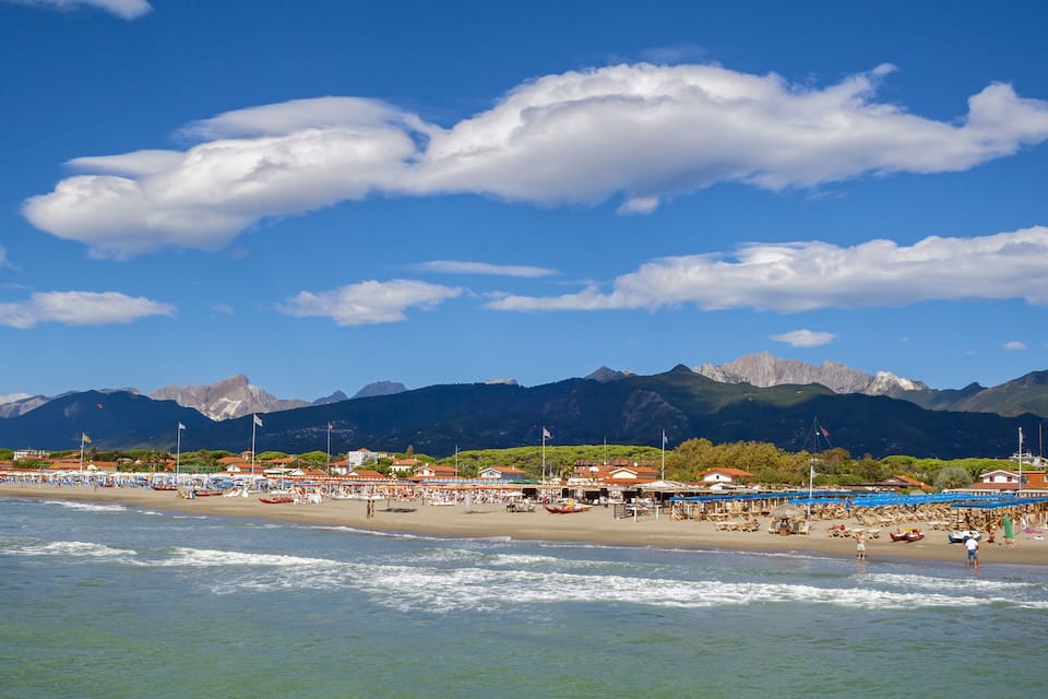 Une plage avec des montagnes en arrière-plan.