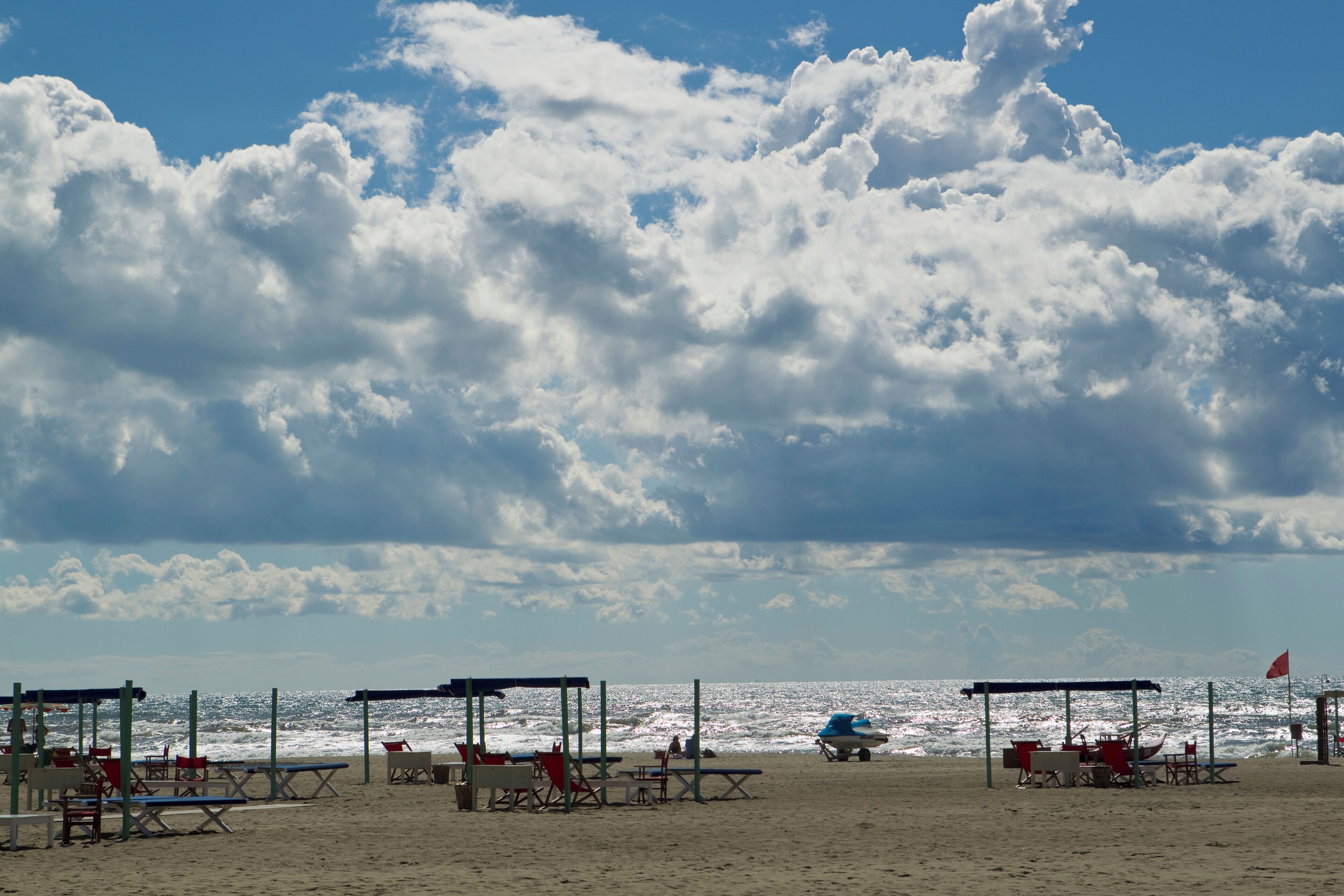 Italy, Forte dei Marmi, View of sandy beach with blue sky and white dense clouds