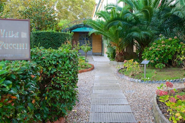 Villa Puccini das einen Garten und Beschilderung