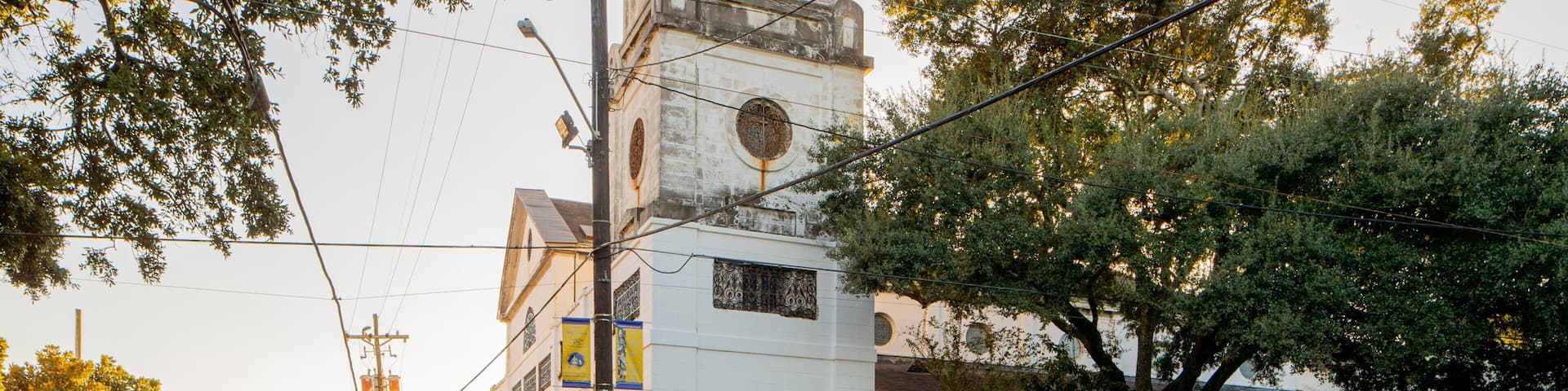 A street with a church, cars, and trees.