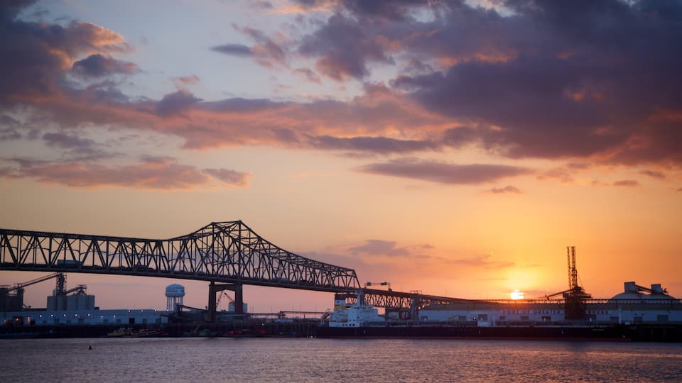 A sunset over a bridge and industrial buildings.