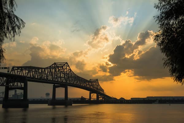 A bridge over a body of water with a sunset in the background.