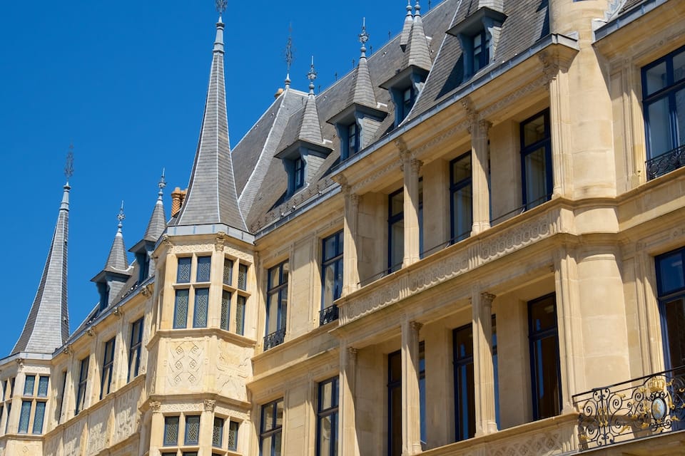 Een historisch gebouw met versierde architectuur, waaronder een toren met puntig dak en decoratieve spitsen.