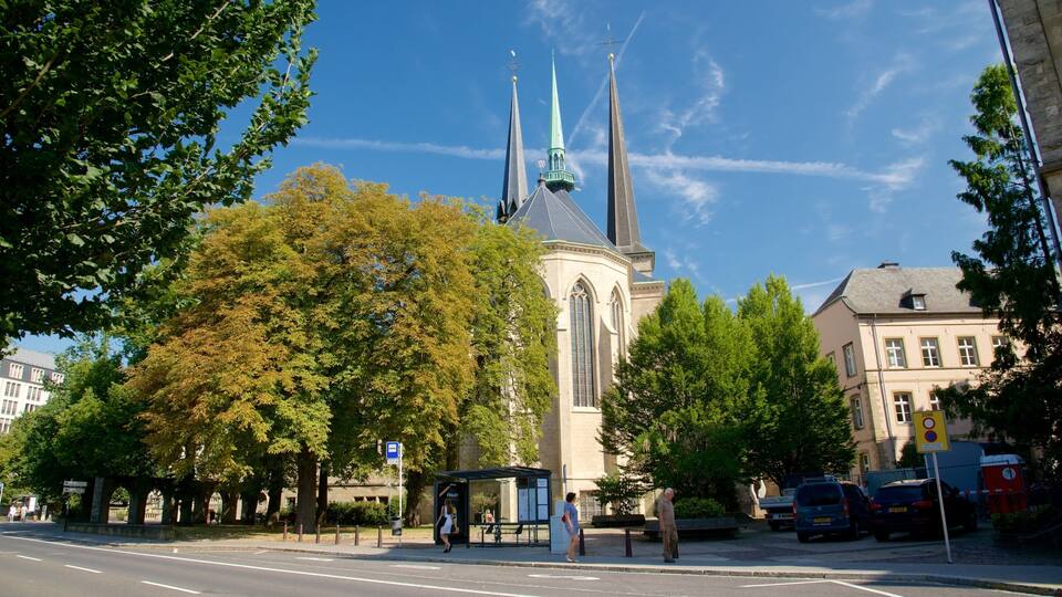 A church with two spires, surrounded by trees and buildings.