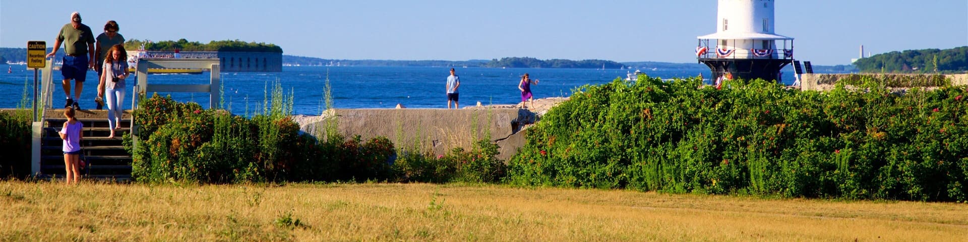 Fort Preble showing a garden and a lighthouse as well as a small group of people