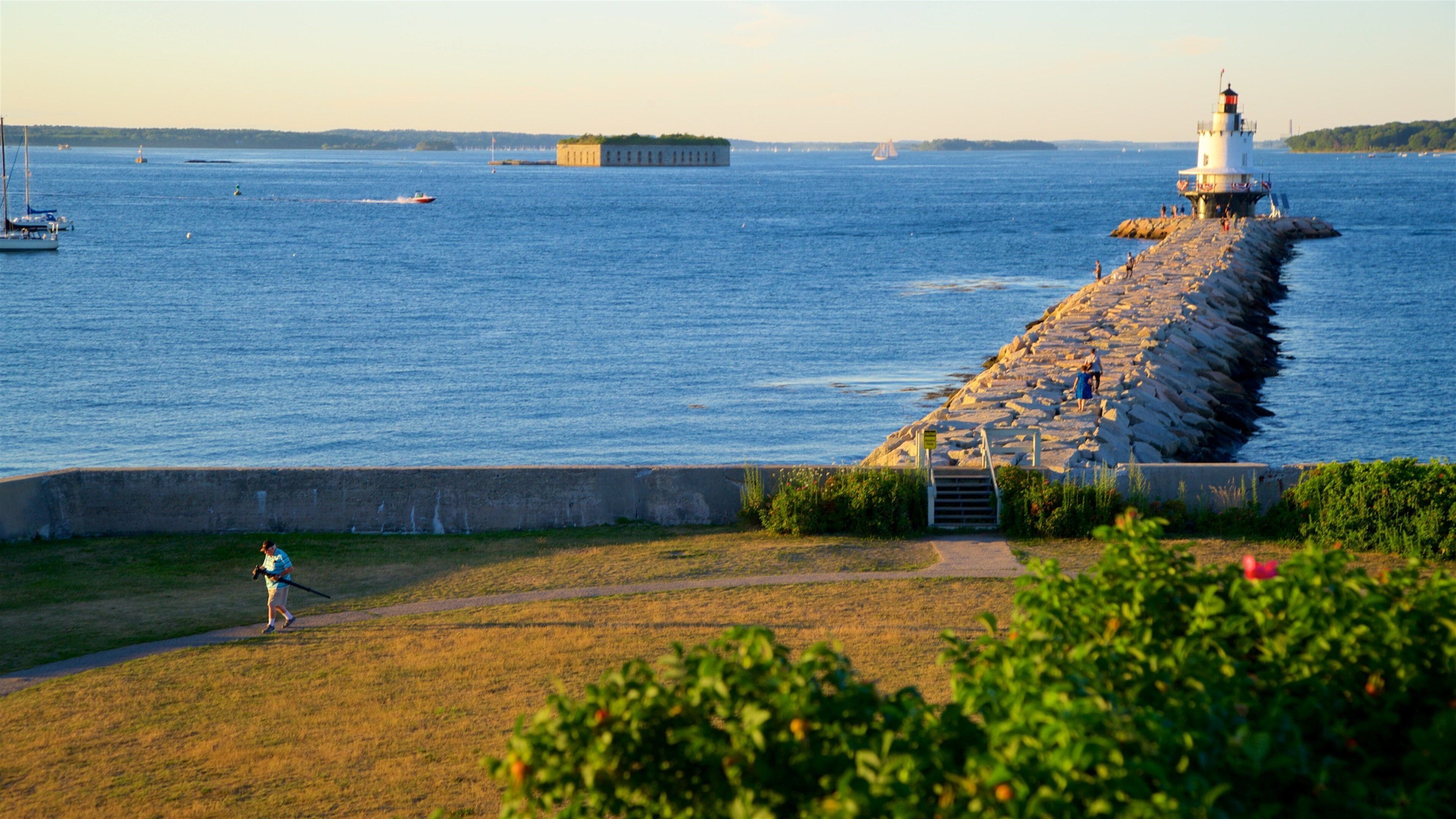 Fort Preble som omfatter et fyrtårn, udsigt over kystområde og en solnedgang