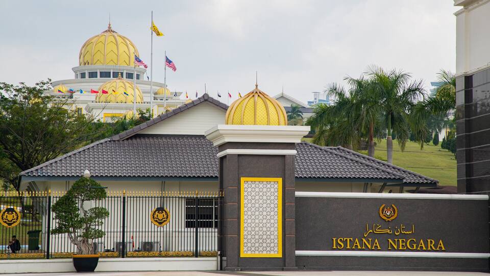 Ein Gebäude mit einer goldfarbenen Kuppel und Flaggen, mit der Aufschrift ISTANA NEGARA.