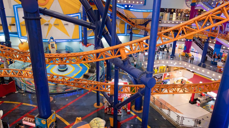 An indoor amusement park with roller coasters, a carousel, and various shops.