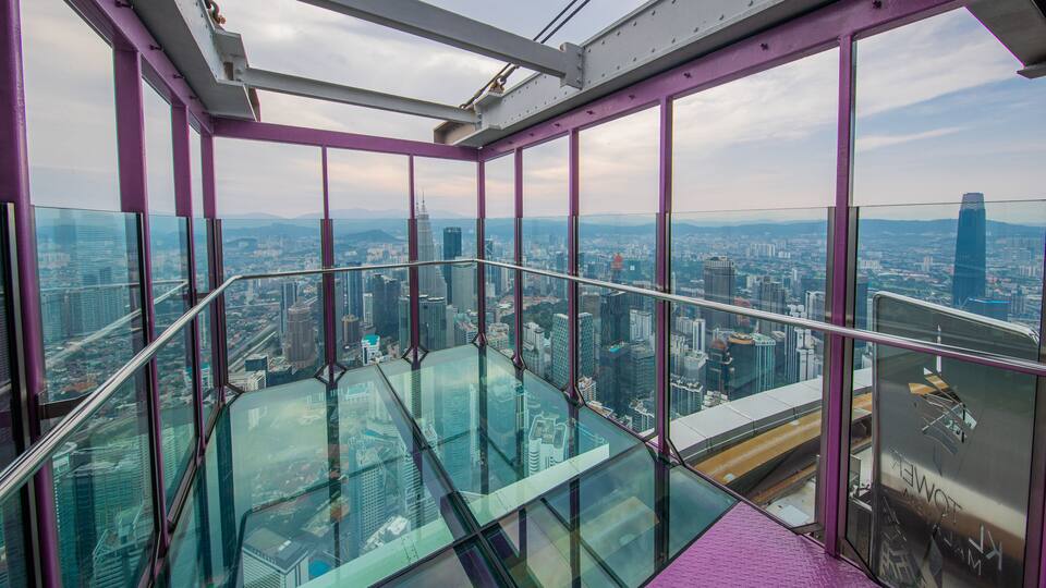 A glass-walled observation deck with a cityscape view.