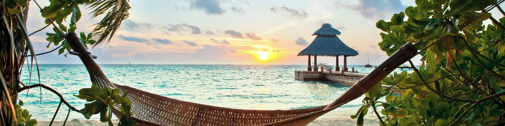 Empty hammock in the tropical beach in the Maldives at sunset