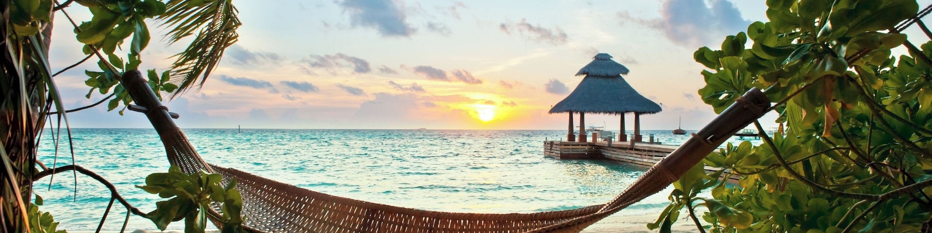 Empty hammock in the tropical beach in the Maldives at sunset
