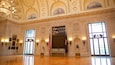 A grand hall with ornate ceilings, large windows, and a prominent 'Don't Give Up the Ship' sign.