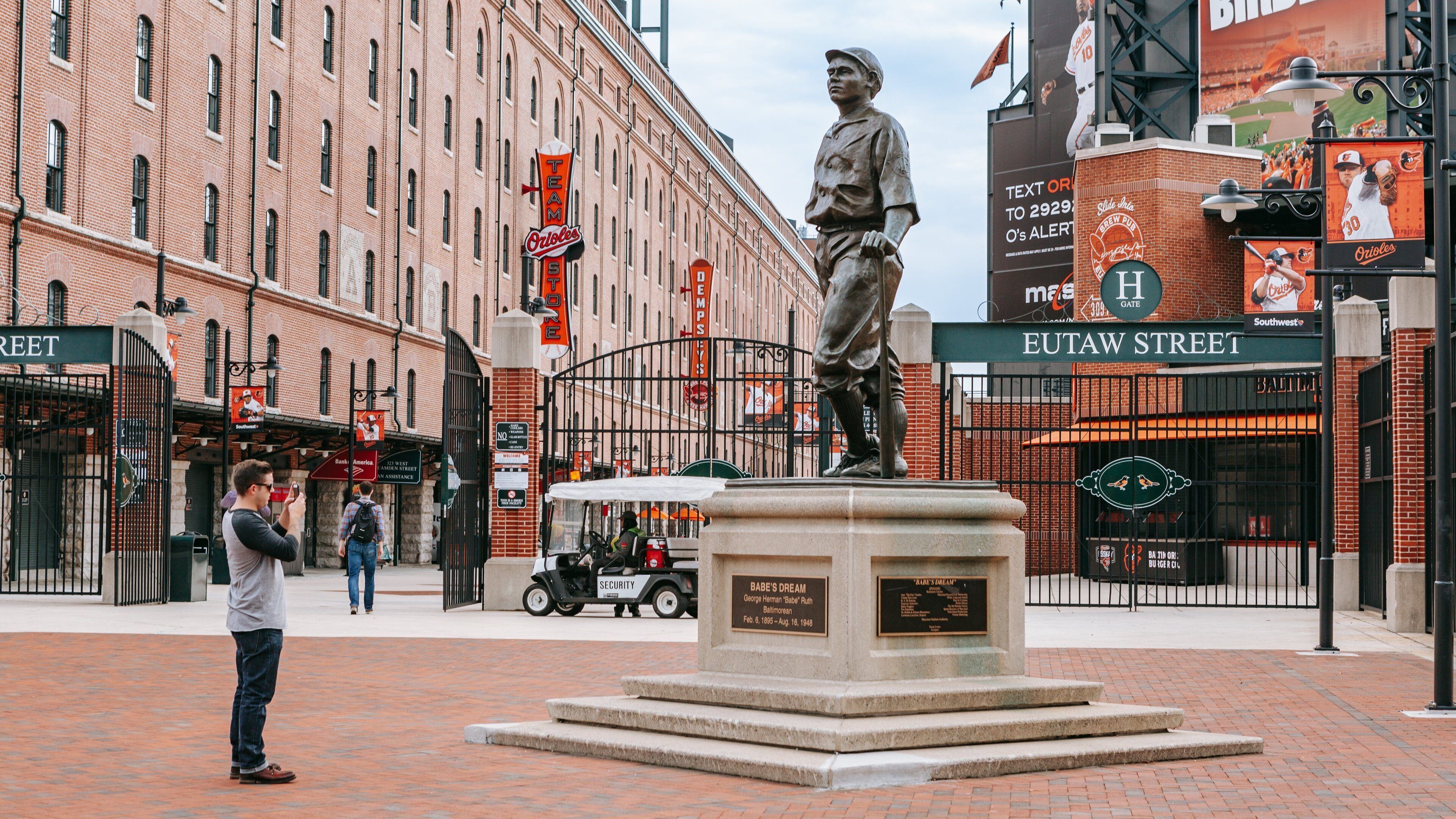 Oriole Park at Camden Yards featuring a statue or sculpture as well as an individual male