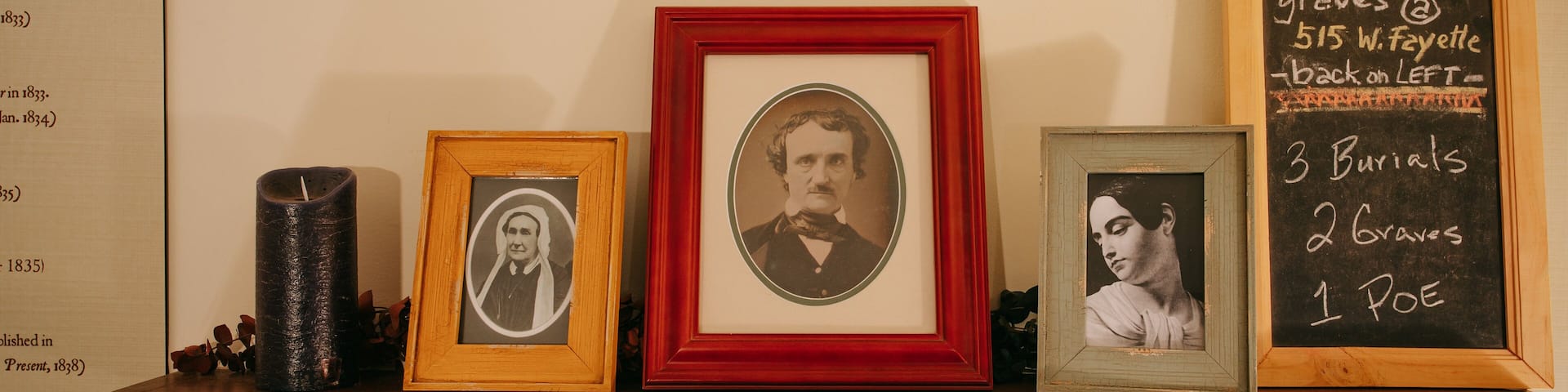 Una estantería con fotografías enmarcadas y una pizarra con información histórica.