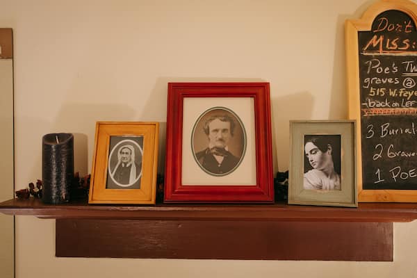 Une étagère avec des photographies encadrées et un tableau noir contenant des informations historiques.