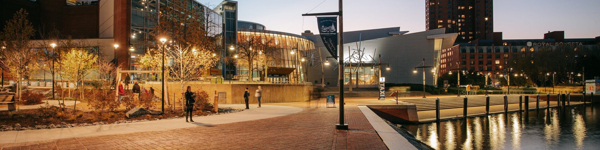 Maryland Science Center which includes a bay or harbor, night scenes and a sunset